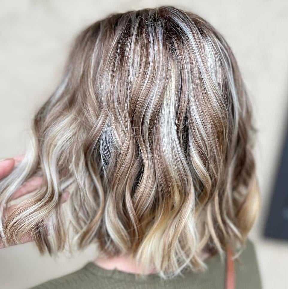 Short wavy blonde hair with highlights in a stylish bob cut.